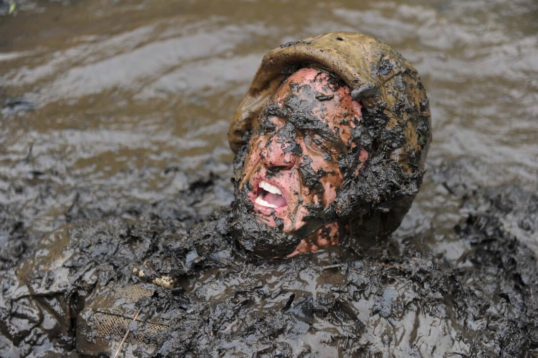 A sergeant instructor emerges from The Quigley, a series of water obstacles, during the Combat Course at Officer Candidates School on May 22, 2013. The OCS staff goes through the obstacles before each training cycle to reaquaint themselves with the different courses.