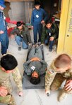 Afghan police officers and U.S. Army Soldiers with the Texas Army National Guard prepare to lift a simulated casualty during combat first aid training at Forward Operating Base Hadrian, Deh Rawud district, Uruzgan province, Afghanistan, Feb. 13, 2013. 