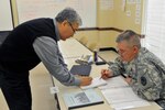 Army Staff Sgt. Curvis Brooks, gets Dari language instruction from his teacher, Tazagul Hussein, during a pilot program.