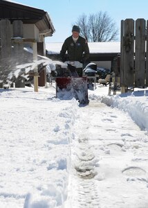 Tech. Sgt. Clay Dotson, 18th Air Refueling Squadron boom operator, uses a snow blower to clear a walkway, Feb. 22, 2013, McConnell Air Force Base, Kan. Much more snow was falling Monday.