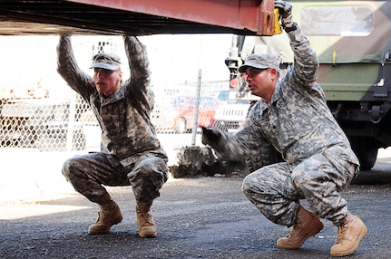 Spc. Rafael Cervantes and Pfc. Rodrigo Gutierrez, of the 1010th Engineer Company, 130th Engineer Battalion, check for hidden compartments on cargo containers as one of their tasks during the state mobilization.