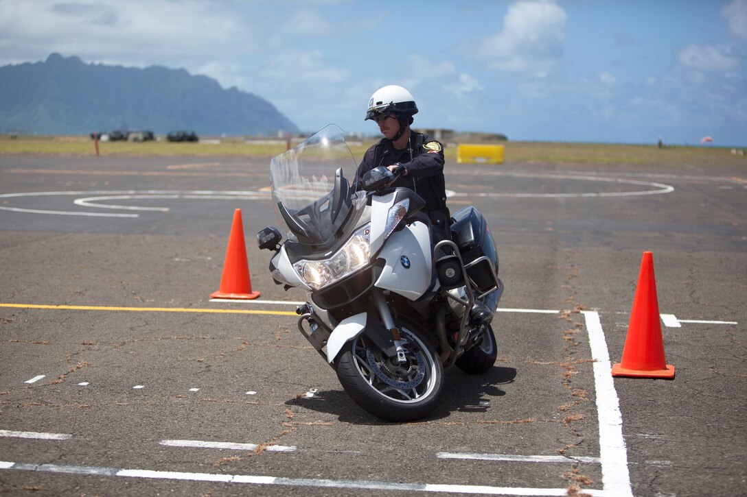Police Officer Joel Warkentin Jr., a motorcycle police officer with Honolulu Police Department, shows his patrolling BMW motorcycle to Marines from 2nd Battalion, 3rd Marine Regiment’s Motorcycle Mentor Program at the Marine Corps Base Hawaii airfield, Aug. 2, 2013. (U.S. Marine Corps photo by Lance Cpl. Suzanna Knotts)