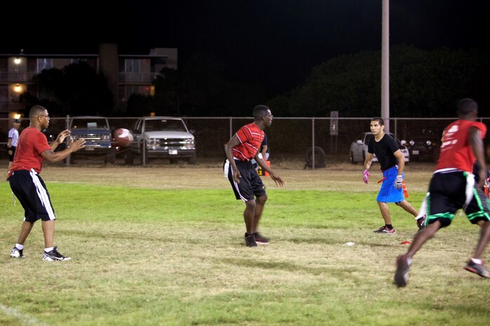 Patrol Squadron 4 players face off with players from Installation Personnel Administration Center during the 101 Days of Summer Flag Football Tournament at Pollock Field, Aug. 5, 2013. The teams were neck and neck throughout the night. (U.S. Marine Corps photo by Lance Cpl. Suzanna Knotts)