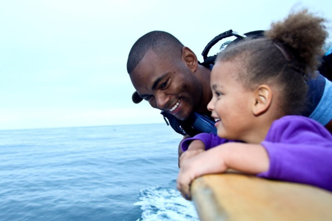 130808-M-ST621-106 DANA POINT, Calif., -- (Aug. 7, 2013) Sergeant Luis S. Martinez, Marine Air Ground Task Force plans chief, Command Element, 15th Marine Expeditionary Unit, enjoys a moment watching dolphins with his daughter Ayla, 5, during a youth fishing trip aboard the fishing vessel Clemente, Aug. 7. Marines and sailors volunteered their time to take youths on an all-day fishing trip sponsored by Wild Game Feed. Martinez is from Brooklyn, N.Y. (U.S. Marine Corps Photo by Cpl. Emmanuel Ramos/Released)