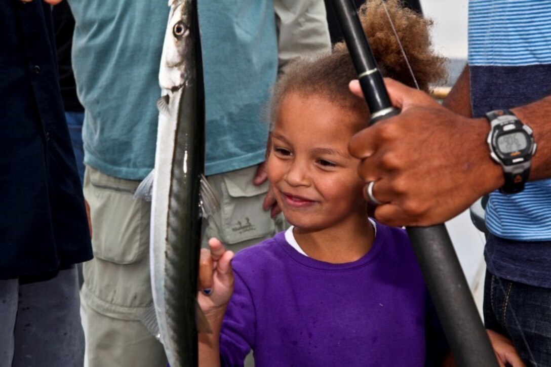 130808-M-ST621-218 DANA POINT, Calif., -- (Aug. 7, 2013) Ayla, 5, examines her freshly caught barracuda during a youth fishing trip aboard the fishing vessel Clemente, Aug. 7. Marines and sailors volunteered their time to take youths on an all-day fishing trip sponsored by Wild Game Feed. (U.S. Marine Corps Photo by Cpl. Emmanuel Ramos/Released)