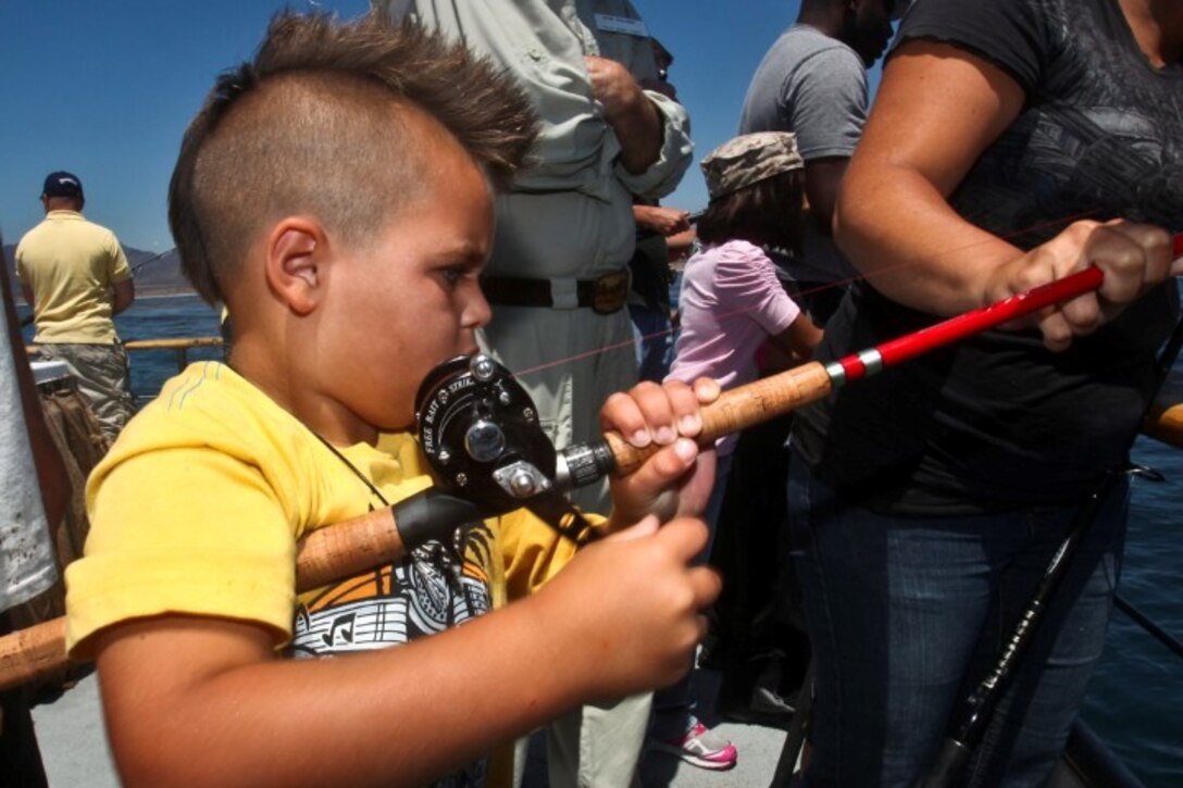 130808-M-ST621-285 DANA POINT, Calif., -- (Aug. 7, 2013) Kolton, 6, struggles to reel in his catch during a youth fishing trip aboard the fishing vessel Clemente, Aug. 7. Marines and sailors volunteered their time to take youths on an all-day fishing trip sponsored by Wild Game Feed. (U.S. Marine Corps Photo by Cpl. Emmanuel Ramos/Released)