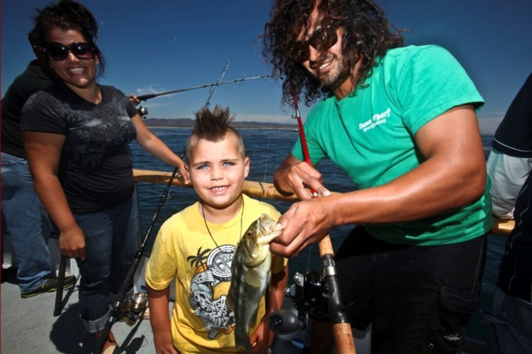 130808-M-ST621-288 DANA POINT, Calif., -- (Aug. 7, 2013) Kolton (left), 6, poses with Marcus Estrada, first deckhand, with his catch, a Calico Bass, during a youth fishing trip aboard the fishing vessel Clemente, Aug. 7.. Marines and sailors volunteered their time to take youths on an all-day fishing trip sponsored by Wild Game Feed. Estrada is a native of Laguna Beach, Calif. (U.S. Marine Corps Photo by Cpl. Emmanuel Ramos/Released)