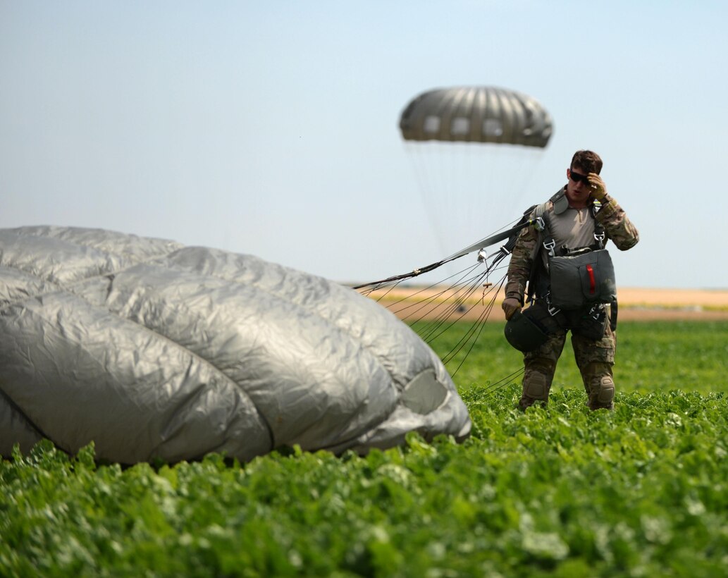 U.S. Air Force Senior Airman Justin Gordon, the assistant noncommissioned officer in charge of survival, evasion, resistance and escape training with the 52nd Operations Support Squadron, completes a static line jump July 26, 2013, at Spangdahlem Air Base, Germany. Gordon participated in the training to maintain his qualifications and also reenlisted prior to the jump. (U.S. Air Force photo by Airman 1st Class Gustavo Castillo/Released)