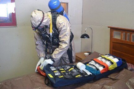 Missouri National Guard Staff Sgt. Matthew Loehr opens a sampling kit during an exercise at Dugway Proving Ground in Utah.