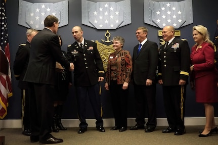 Army Capt. Matthew Sadler, commander of the South Dakota Army National Guard's 842nd Engineer Company, shakes hands with John Hastings, principal deputy, assistant secretary of defense for reserve affairs, while accepting the Department of Defense Reserve Family Readiness Award on behalf of his unit during a ceremony at the Pentagon, March 1, 2013.