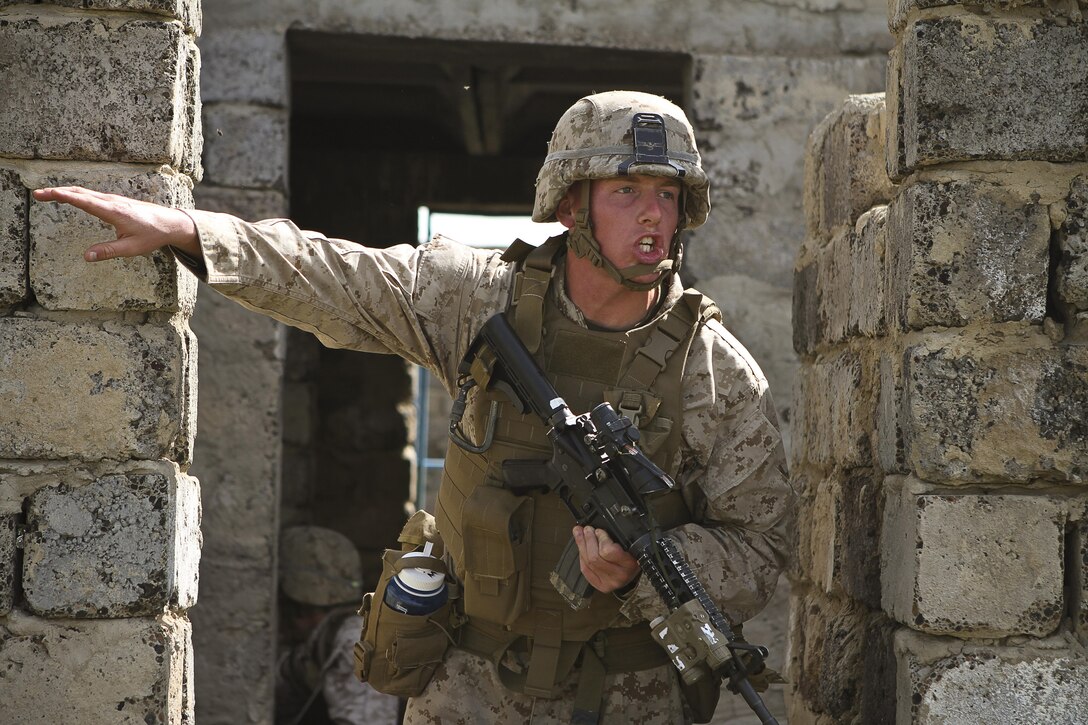 U.S. Marine Lance Cpl. Nicholas Moore with 3rd Battalion, 3rd Marine Regiment, 3rd Marine Division shouts orders to other memers of his team during a cordon and search lane ledt by members of the Mongolian Armed Forces, Australian Army South Korean Army and U.S. Soldiers and Marines at Five Hills Training Area, Mongolia on Aug. 08, 2013. Khaan Quest is an annual multinational exercise sponsored by the U.S. and Mongolia, and it is designed to strengthen the capabilities of U.S., Mongolian and other nations' forces in international peace support operations. 