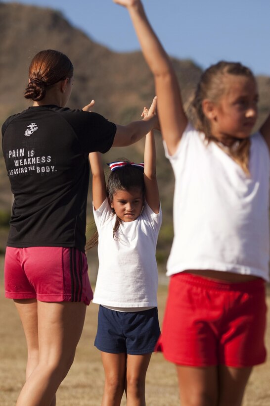 Cheer coach Allison Devris, coaches one of her cheerleaders on technique during cheerleading practice at Landing Zone Eagle across from Fort Hase Beach, Aug. 5, 2013. (U.S. Marine Corps photo by Lance Cpl. Janelle Y. Chapman) 

