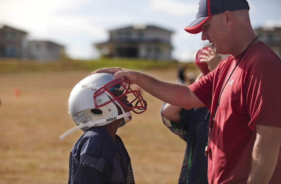 Duncan Buchanan, a volunteer youth football coach for the Mighty Mites’ division Patriots team, offers words of encouragement to his players during practice, Aug. 5, 2013. (U.S. Marine Corps photo by Lance Cpl. Janelle Y. Chapman)  
