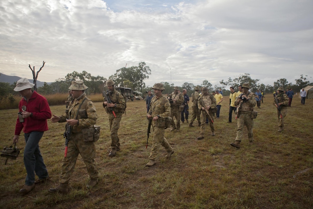 Australian forces are escorted by the mayor of Waratah Village, (far left), to sit down for initial talks in hopes of reaching a mutual friendship during Exercise Talisman Saber 2013, July 22, 2013. (U.S. Marine Corps photo by Lance Cpl. Matthew Bragg)