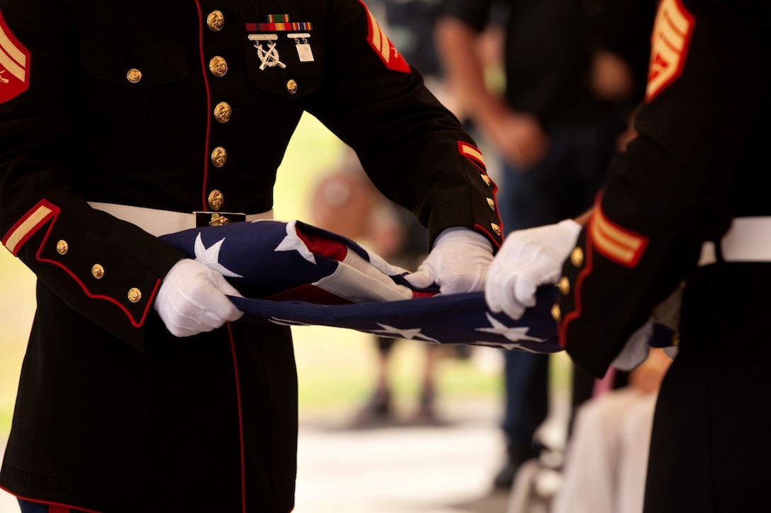 Marines fold a flag after giving full military honors to the late retired Sgt. Maj. Robert F. Porter during his funeral service, Aug. 2, 2013, at Hawaii State Veterans Cemetery in Kaneohe, Hawaii. Porter served 30 years in the Marine Corps, which included service in World War II, Korea and two tours in Vietnam. (U.S. Marine Corps photo by Cpl. Sarah Dietz)