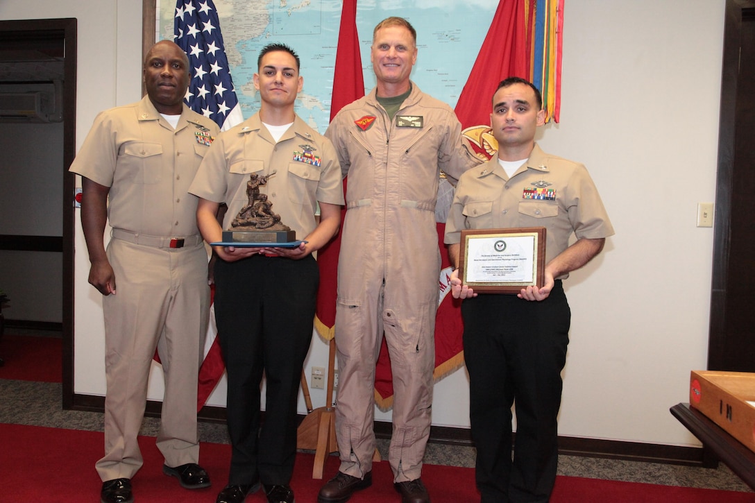 (From left to right) Master Chief Petty Officer David D. Jones, Petty Officer 1st Class Joseph S. De La Cruz, Brig. Gen. Steven R. Rudder and Petty Officer 1st Class Michael J. Pena pose Aug. 2 at Building 1 on Camp Foster following an awards ceremony. De La Cruz was presented the Independent Duty Corpsman of the Year award, and Pena received the Robert Graham Enlisted Award for his performance in support of the Naval Aerospace and Physiology Program. Rudder is the commanding general of the 1st Marine Air Wing, III Marine Expeditionary Force. Jones is the command master chief with 1st MAW, III MEF. De La Cruz is an independent duty corpsman with Marine Wing Support Squadron 172, Marine Aircraft Group 36, 1st MAW, III MEF, and Pena is an air medical safety corpsman with MAG-36, 1st MAW, III MEF. 