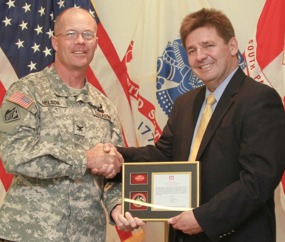 Col. Andrew Nelson, U.S. Army Corps of Engineers, South Pacific Division deputy commander awards Julio Arocho, USACE South Pacific Division Military Integration Division chief after his 15 month deployment to Afghanistan on Aug. 1, 2013 at SPD Headquarters in San Francisco, Calif. Arocho served as the Deputy District Engineer for Programs and Project Management, U.S. Army Corps of Engineers, Afghanistan Engineer District-South and successfully led the district through construction of 57 projects valued in excess of $516M, and award of 66 new projects valued in excess of $855M. (U.S. Army photo by Liviu Tanase/Released)