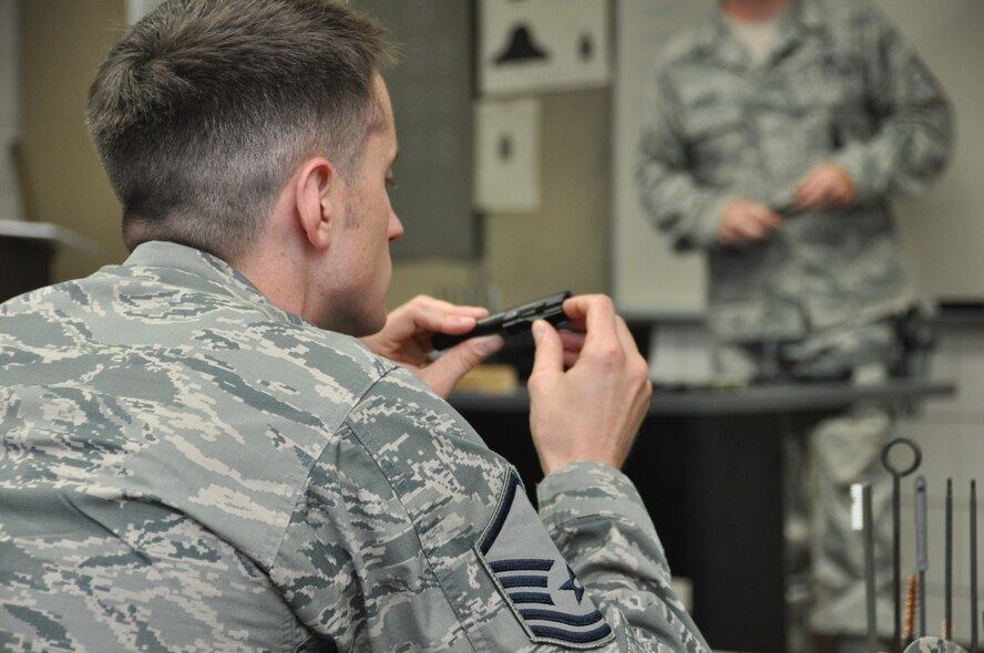 Master Sgt. John Harris a member of the 477th Security Forces Squadron inspects his M-9 barrel during a combat arms training class held during the August Unit Training Assembly weekend here August 3. The combat arms instructors explained the functions of the weapon as well as safety requirements and proper weapon handling techniques. (U.S. Air Force/Tech. Sgt. Dana Rosso)