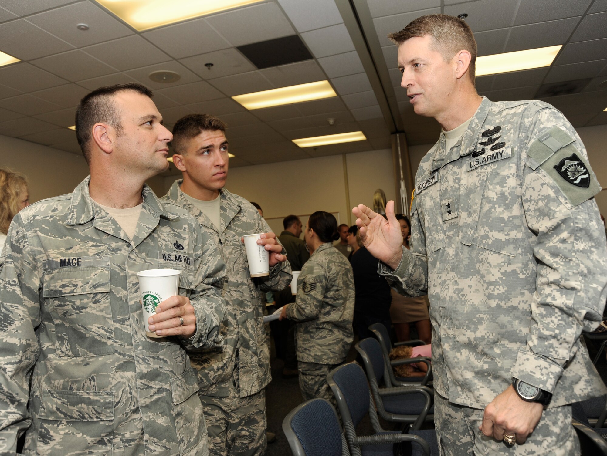 Maj. Gen. Daniel Hokanson, Oregon Adjutant General (right) discusses aspects of the recent deployment by Tech. Sgt.  Daniel Mace and Senior Airman Benjamin Courtney (left) during a USO event held at the Portland Air National Guard Base, Ore., Aug. 9, 2013. A total of 26 Airmen from the 142nd Fighter Wing spent six months in Qatar in support of Operation Enduring Freedom. (Air National Guard photo by Tech. Sgt. John Hughel, 142nd Fighter Wing Public Affairs/released)