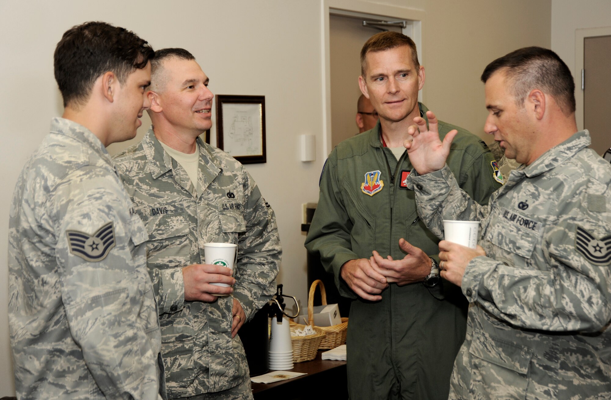 Oregon Air National Guard Col. Rick Wedan, 142nd Fighter Wing Commander (center-right) listens to Tech. Sgt. Daniel Mace (far-right), Staff Sgt. James Kalmback (left) and Tech. Sgt. Steven Davis (center-left) of the 142nd Fighter Wing Security Forces Squadron, during an in processing USO event held at the Portland Air National Guard Base, Ore., Aug. 9, 2013. (Air National Guard photo by Tech. Sgt. John Hughel, 142nd Fighter Wing Public Affairs/released)