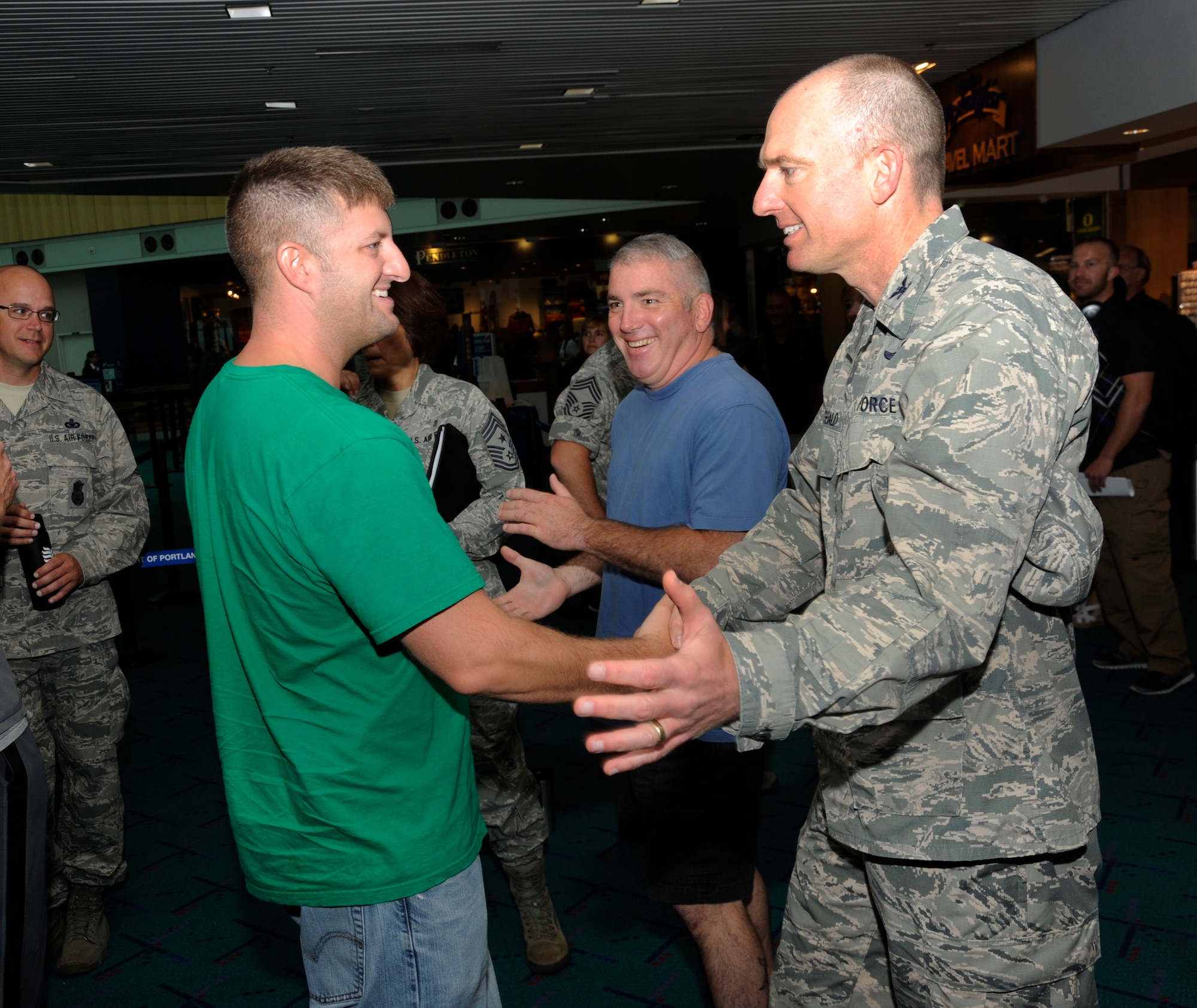 Members of the 142nd Fighter Wing Security Forces Squadron are welcomed back to Oregon at the Portland International Airport after their recent deployment, Aug. 8, 2013. A total of 26 Airmen from the 142nd Fighter Wing spent six months in Qatar in support of Operation Enduring Freedom. (Air National Guard photo by Tech. Sgt. John Hughel, 142nd Fighter Wing Public Affairs/released)