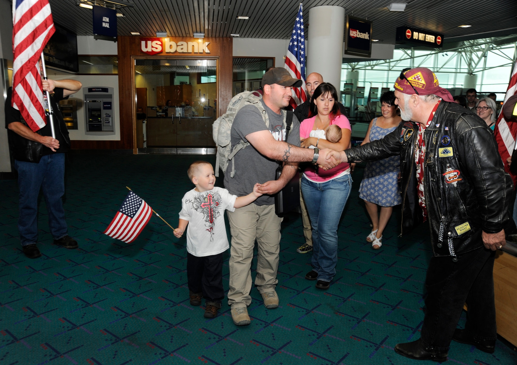 Members of the 142nd Fighter Wing Security Forces Squadron are welcomed back to Oregon at the Portland International Airport after their recent deployment, Aug. 8, 2013. A total of 26 Airmen from the 142nd Fighter Wing spent six months in Qatar in support of Operation Enduring Freedom. (Air National Guard photo by Tech. Sgt. John Hughel, 142nd Fighter Wing Public Affairs/released)