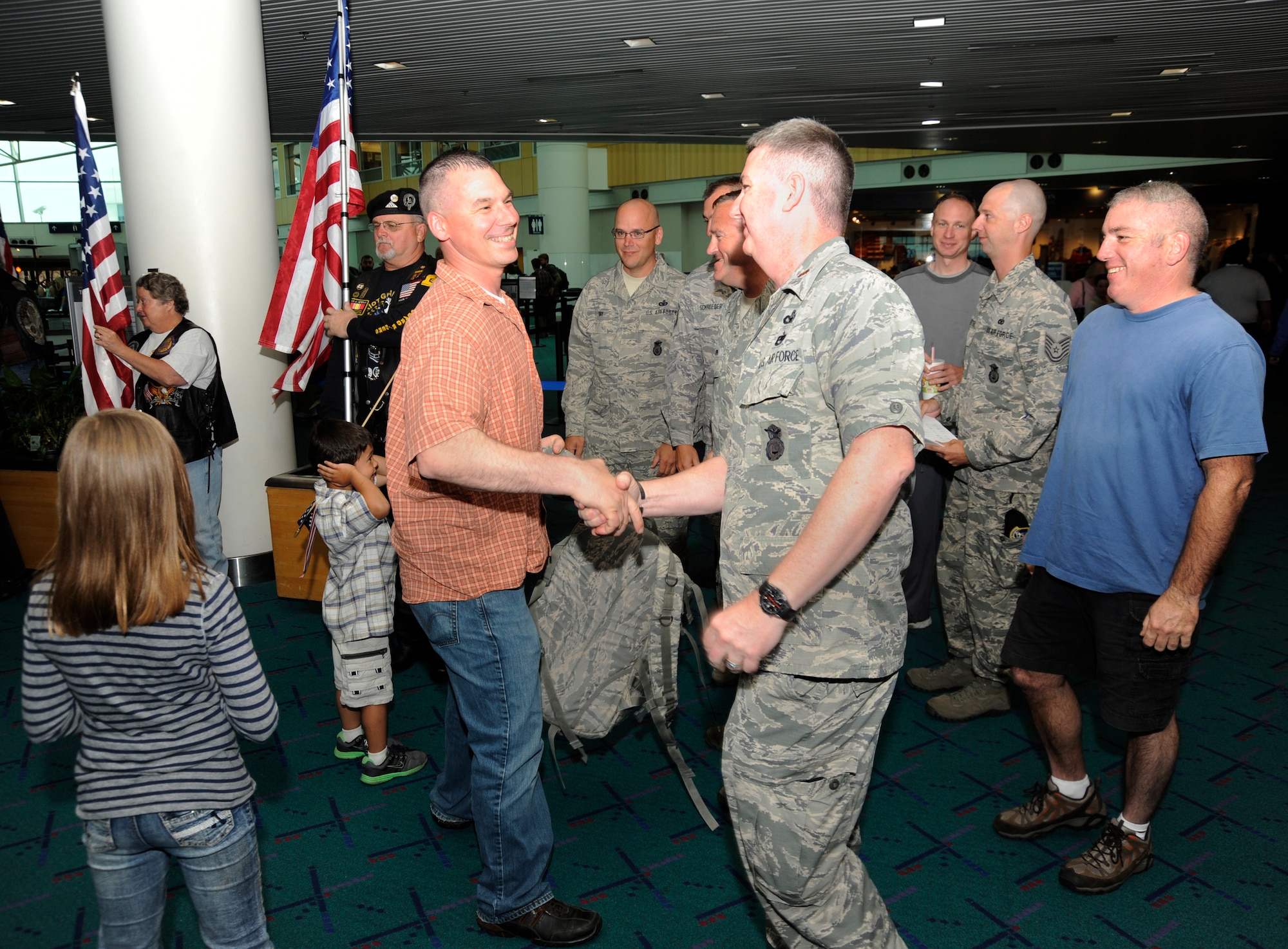 Members of the 142nd Fighter Wing Security Forces Squadron are welcomed back to Oregon at the Portland International Airport after their recent deployment, Aug. 8, 2013. A total of 26 Airmen from the 142nd Fighter Wing spent six months in Qatar in support of Operation Enduring Freedom. (Air National Guard photo by Tech. Sgt. John Hughel, 142nd Fighter Wing Public Affairs/released)