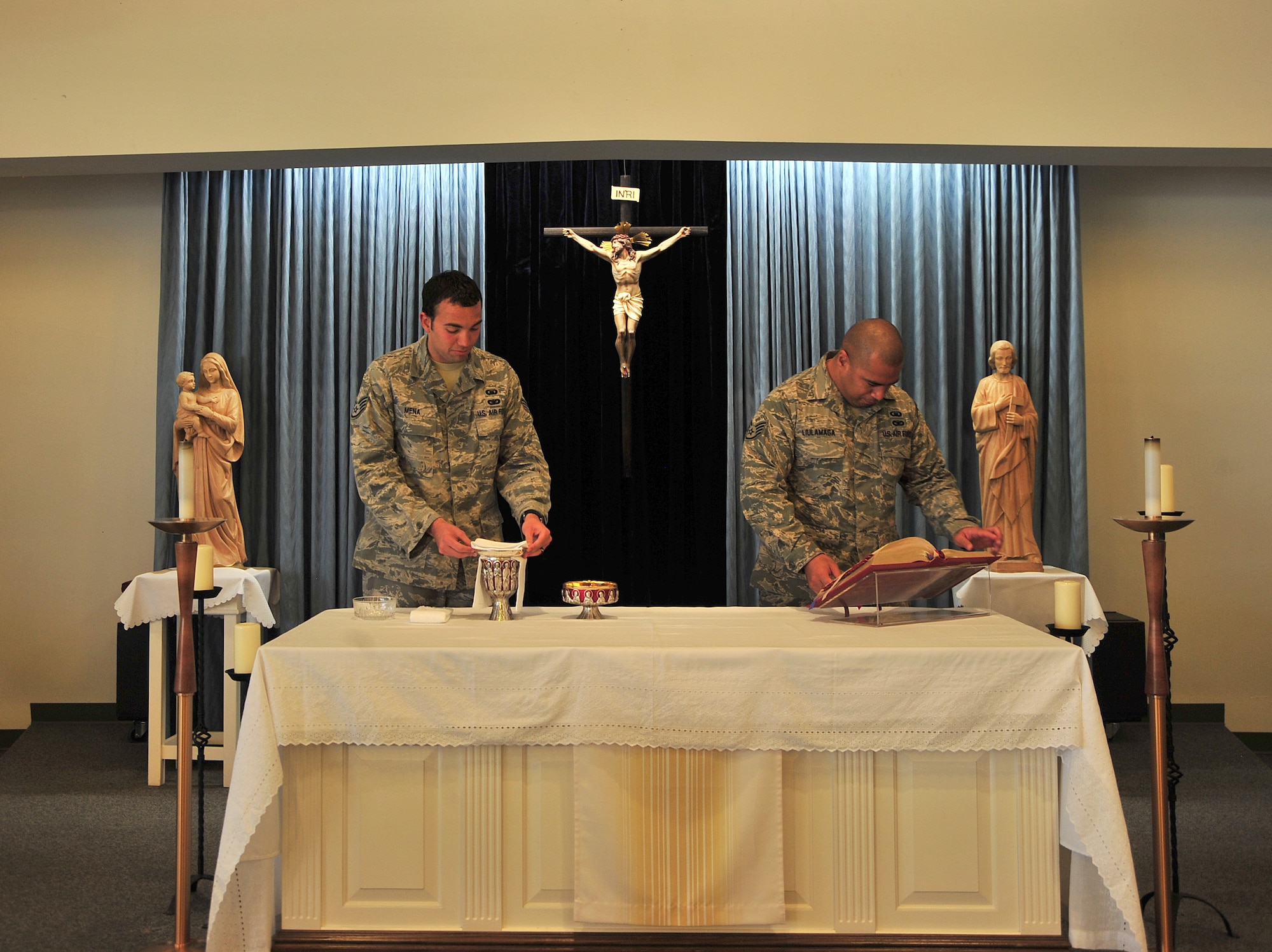 U.S. Air Force Staff Sgt. George Mena (left) and Staff Sgt. Misinimese Liulamaga, 355th Fighter Wing chaplains assistants, set up mass at Davis-Monthan Air Force Base, Ariz., August 8, 2013. Mena and Liulamaga prepare the chapel each day for mass.(U.S. Air Force photo Airman 1st Class Josh Slavin/Released)