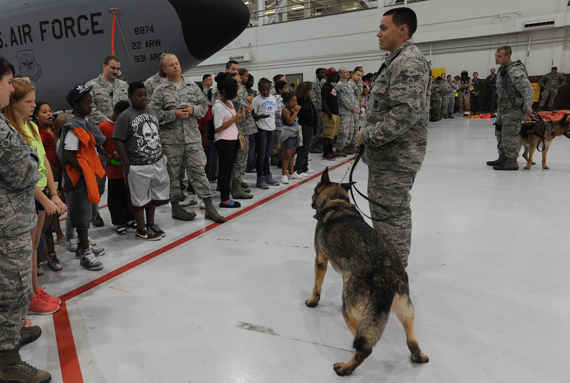 Senior Airmen Chad Ditch and Brian Claypool, 22nd Security Forces Squadron military working dog handlers, talk with “Littles” during the annual Big for a Day event Aug. 9, 2013, at McConnell Air Force Base, Kan. Team McConnell hosted approximately 50 children from the Sedgwick County chapter of the Big Brothers Big Sisters organization. (U.S. Air Force photo/2nd Lt. Jessica Brown)