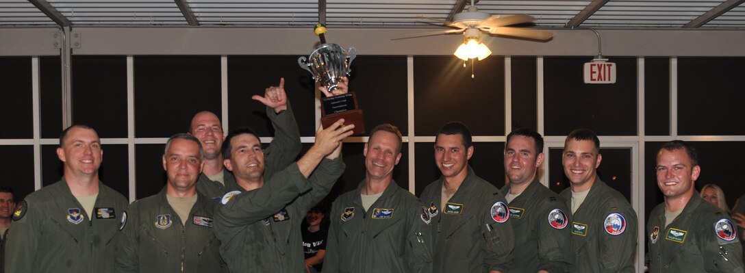 The rotating 14th Flying Training Wing Crud tournament trophy is lifted high into the air by the victorious 50th Flying Training Squadron Team A during the annoucement of the official winners by 14th FTW commander Col. Jim Sears Aug. 2 at the Columbus Club.  Sears is flanked to the right by the second place team, the 49th Black Knights. (U.S. Air Force Photo/Richard Johnson)