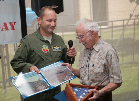 Col. Gentry Boswell, 28th Bomb Wing vice commander, presents Ernie Miller, a World War II veteran, with a U.S. flag flown over Mount Rushmore and the Black Hills area during the 2013 Dakota Thunder Run at Sturgis, S.D., Aug. 6, 2013. Miller was drafted by the Army in 1945 and completed his training in bomb and ammunition disposal at the Aberdeen Proving Grounds, Md. During his time in the Army he was stationed overseas in the Philippine Islands and the Pacific Theater in Japan before returning home in the fall of 1946. (U.S. Air Force photo by Airman 1st Class Zachary Hada/Released)