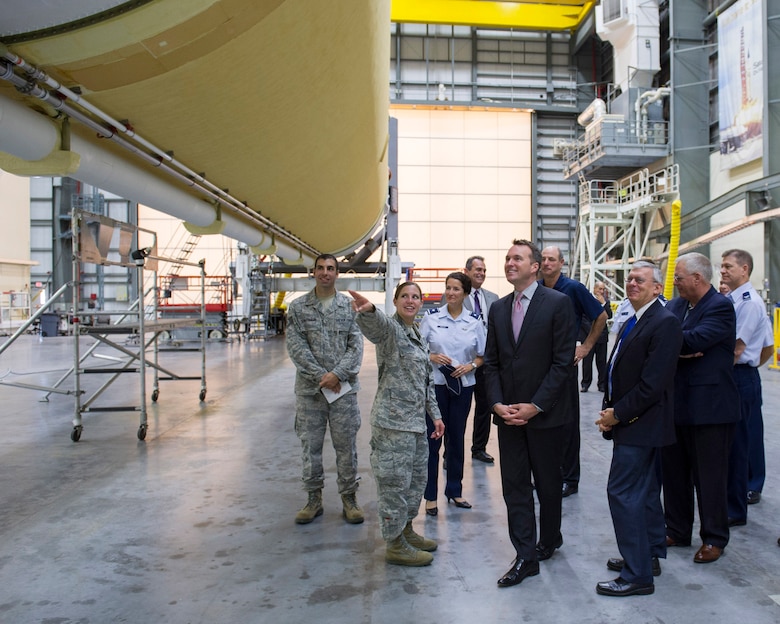 Acting Secretary of the Air Force Eric Fanning along with Brig. Gen. Nina Armagno, 45th Space Wing commander, view a Delta IV launch vehicle during his tour of the Horizontal Integration Facility at Cape Canaveral Air Force Station Aug. 8 given by 1st Lt. Danielle DePaolis, 5th Space Launch Squadron engineer (left).