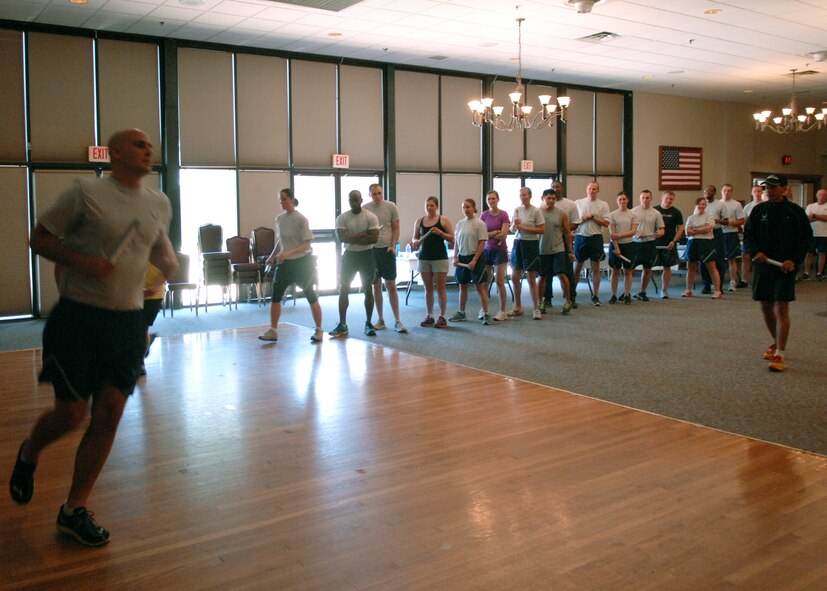 U.S. Air Force Lt. Col. Antonio Eppolito, Air Force Medical Support Agency, evaluates jogging form during a running seminar Aug. 7, 2013, at the Dyess Event Center on Dyess Air Force Base, Texas. During the seminar, Eppolito provided the members with information on aerobic development, running form, injury prevention and how to improve performance. He educated servicemembers on the barefoot style running, which is more efficient for the body by limiting pain and injuries. This can be accomplished by wearing a minimalist running shoe. According to Eppolito, wearing thick-heeled tennis shoes force people to land on their heels, which causes more injuries and shortens the achilles tendon by limiting flexibility in the foot. Eppolito has been a member of the Air Force running team for 18 years and is a five-time Air Force Masters Half-Marathon champion. (U.S. Air Force photo by Senior Airman Shannon Hall/Released)