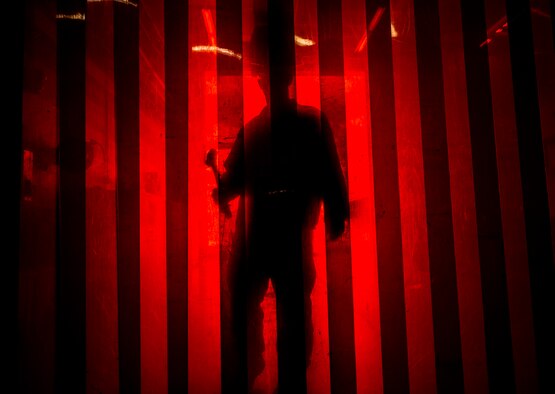 Master Sgt. Tim Thornton, 437th Maintenance Squadron aircraft metals shop noncommissioned officer in charge, walks towards arc welding protection drapes with a sledge hammer in his hands Aug. 7, 2013, at Joint Base Charleston, S.C. The red drapes protect individuals not wearing a welding shield from taking in the intense light emitted during welding produces. (U.S. Air Force photo/Senior Airman Dennis Sloan) 

