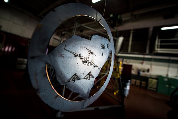 A sheet metal sign with a C-17 Globemaster III, the Arthur Ravenel Jr. Bridge and a Palmetto tree with a crescent, hangs in the 437th Maintenance Squadron aircraft metals shop Aug. 7, 2013, at Joint Base Charleston, S.C. Airmen from the aircraft metals fabrication shop are trained to use several different pieces of equipment to bend, cut and combine metals. (U.S. Air Force photo/Senior Airman Dennis Sloan)