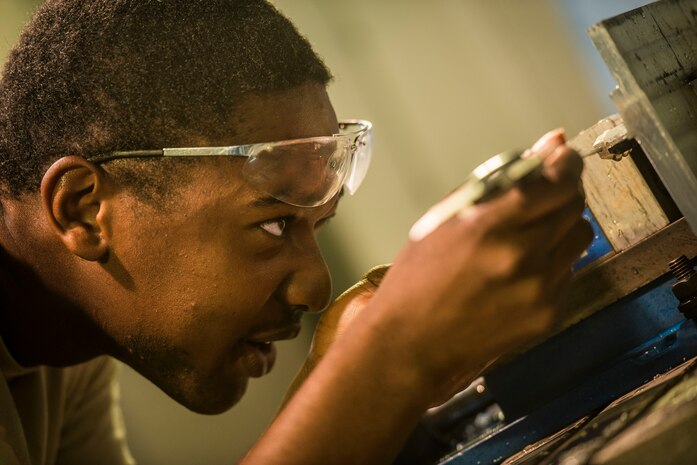 Airman 1st Class Tashma Antoine, 437th Maintenance Squadron aircraft metals apprentice, measures a piece of aluminum before cutting it on a lathe Aug. 7, 2013, at Joint Base Charleston, S.C. Airmen from the aircraft metals fabrication shop are trained to use several different pieces of equipment to bend, cut and combine metals. (U.S. Air Force photo/Senior Airman Dennis Sloan)