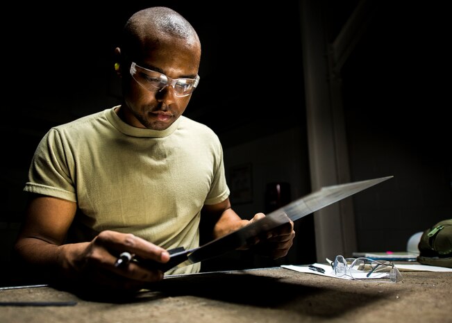 Airman 1st Class William Williams, 437th Maintenance Squadron aircraft metals technology journeyman, prepares to lay out a cut with a ruler and black marker on a sheet of metal Aug. 7, 2013, at Joint Base Charleston, S.C. The sheet metal is used to simulate steel work on a C-17 Globemaster III wing. (U.S. Air Force photo/Airman 1st Class Dennis Sloan)