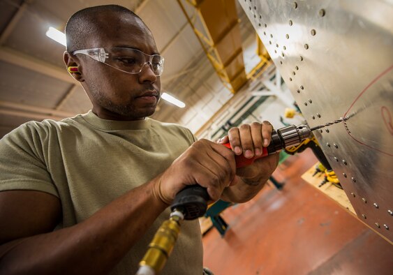 Airman 1st Class William Williams, 437th Maintenance Squadron aircraft metals technology journeyman, drills holes into a sheet of metal during training Aug. 7, 2013, at Joint Base Charleston, S.C. The sheet metal is used to simulate steel work on a C-17 Globemaster III wing. (U.S. Air Force photo/Senior Airman Dennis Sloan) 

