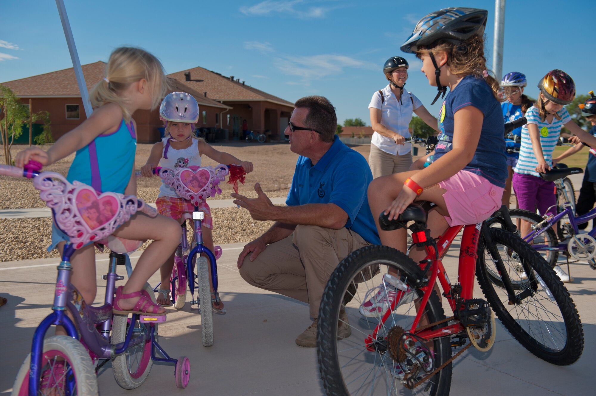 Bruce Roberts, 49th Security Forces Squadron Community Police officer, teaches members of Team Holloman dependants about practicing safe riding habits during the Bike Rodeo at Holloman Air Force Base, N.M., Aug. 7. The Bike Rodeo program teaches children about safe riding habits and proper use of protective equipment by engaging them with safety scenarios and skill games. (U.S. Air Force photo by Airman 1st Class Aaron Montoya/Released)