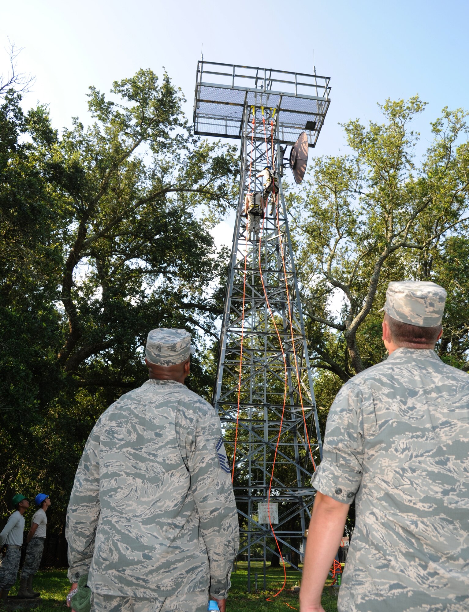 Senior Airman Joey Peay and Staff Sgt. Nathan Williams, 85th Engineering Installation Squadron, climb a training tower for a demonstration of a tower rescue maneuver during an 81st Training Wing leadership tour of the 85th EIS on Aug. 8, 2013, at Maltby Hall, Keesler Air Force Base, Miss.  The purpose of the tour was to educate leadership on the unique services and day-to-day operations of the Air Force’s only active duty engineering installation squadron.  (U.S. Air Force photo by Kemberly Groue)