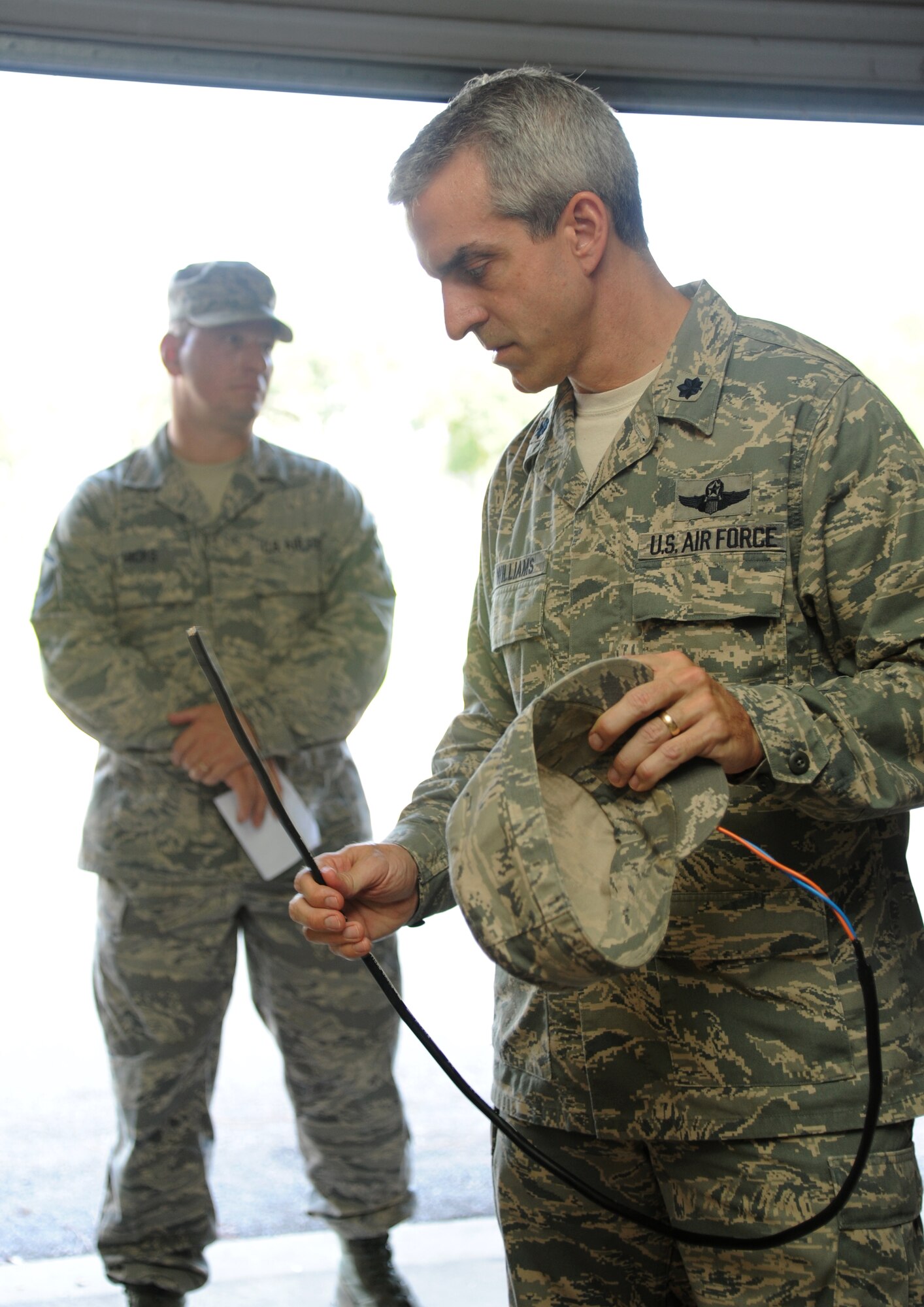 Lt. Col. Craig Williams, 81st Training Wing safety office chief, inspects a fiber optic cable used for communication during an 81st TRW leadership tour of the 85th Engineering installation Squadron on Aug. 8, 2013, at Maltby Hall, Keesler Air Force Base, Miss.  The purpose of the tour was to educate leadership on the unique services and day-to-day operations of the Air Force’s only active duty engineering installation squadron.  (U.S. Air Force photo by Kemberly Groue)