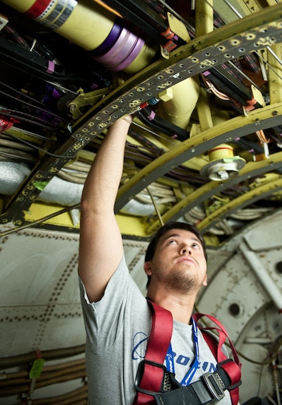 Larry Stratton, Boeing Company B-1 structural analysis engineer, inspects rivet holes for doubling straps during a B-1 structural modification at Ellsworth Air Force Base, S.D., Aug. 6, 2013. By adding this new modification the B-1 will not only be more aerodynamic in flight, but the doubling straps will also strengthen the backbone of the aircraft. (U.S. Air Force photo by Airman 1st Class Alystria Maurer/Released)