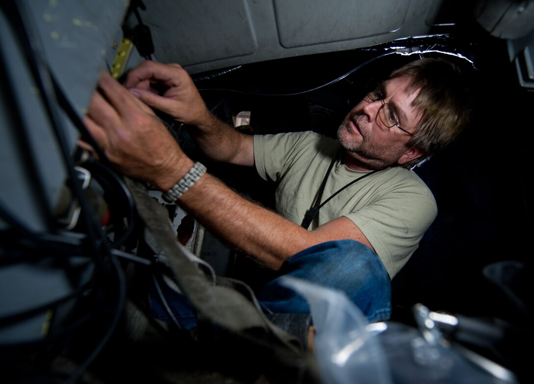 Joe Johengen, 28th Aircraft Maintenance Squadron electrical technician, installs a universal serial bus into a B-1 during a temporary modification at Ellsworth Air Force Base, S.D., Aug. 6, 2013. The new screen improves the way aircrews view locations and confirm targets prior to deploying weapons. (U.S. Air Force photo by Airman 1st Class Alystria Maurer/Released)