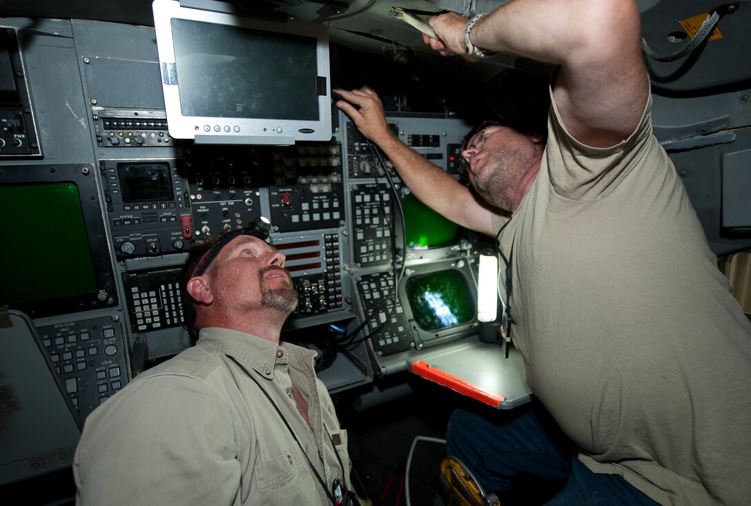 Nathan Lange, 28th Aircraft Maintenance Squadron avionics technician, and Joe Johengen, 28th AMXS electrical technician, install a new display screen in the rear cockpit of a B-1 during a temporary modification trial at Ellsworth Air Force Base, S.D., Aug. 6, 2013. The new display will increase the aircrew’s ability to quickly identify targets. (U.S. Air Force photo by Airman 1st Class Alystria Maurer/Released)