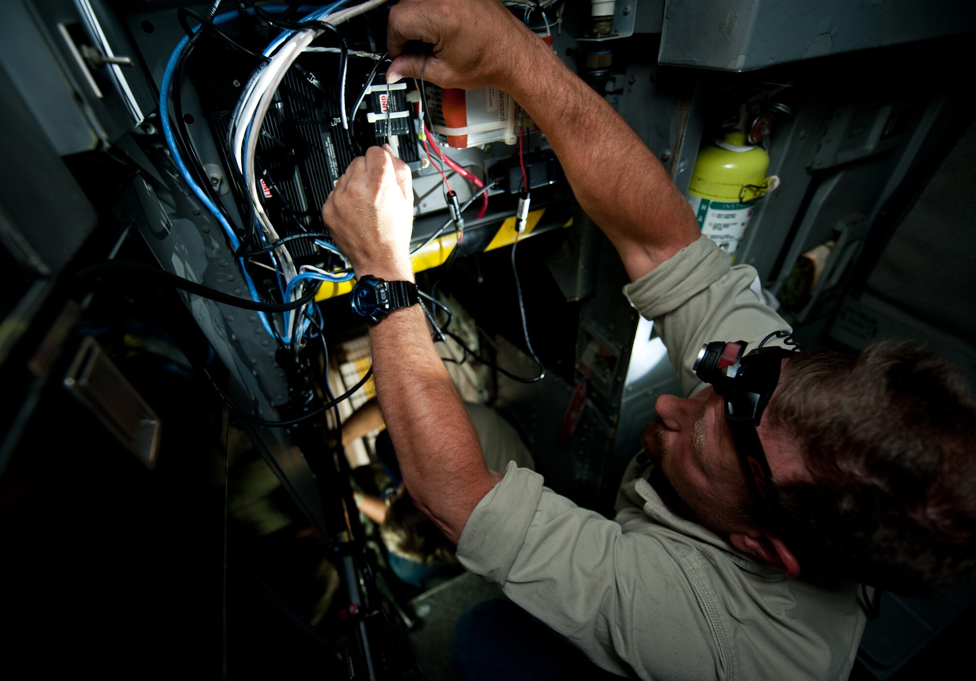 Nathan Lange, 28th Aircraft Maintenance Squadron avionics technician, installs a new display screen in the back of the B-1 cockpit for a trial test of a temporary modification at Ellsworth Air Force Base, S.D., Aug. 6, 2013. The modification equips aircrews with the capability to view moving ground maps on a color display and video from the sniper pod to identify targets. (U.S. Air Force photo by Airman 1st Class Alystria Maurer/Released)