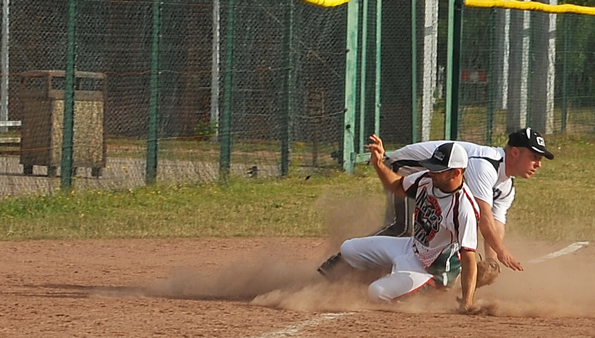 A player from the Naples Elite slides into third base, July 9, 2013, Ramstein Air Base, Germany. The Ramstein Men’s Varsity Softball team hosted the largest tournament in Europe. Twenty-one teams, 15 men’s and six women’s teams competed from all over the region. These teams gathered together to claim victory. (U.S. Air Force photo/Airman Dymekre Allen)