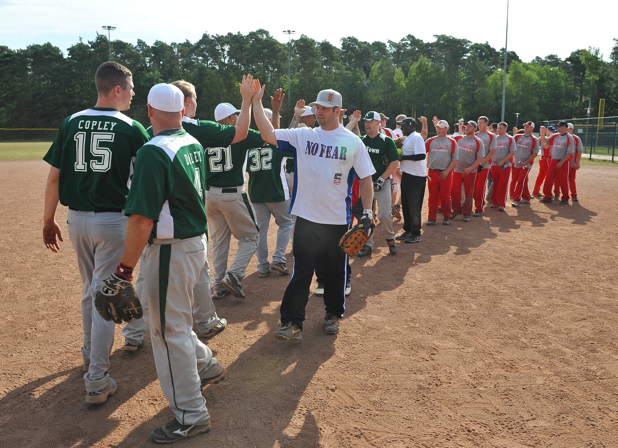 The Stuttgart Stallions and the Kaiserslautern KTown teams celebrate a well played game, July 9, 2013, Ramstein Air Base, Germany. The Ramstein Men’s Varsity Softball team hosted the largest tournament in Europe. Twenty-one teams, 15 men’s and six women’s teams competed from all over the region. These teams gathered together to claim victory. (U.S. Air Force photo/Airman Dymekre Allen)