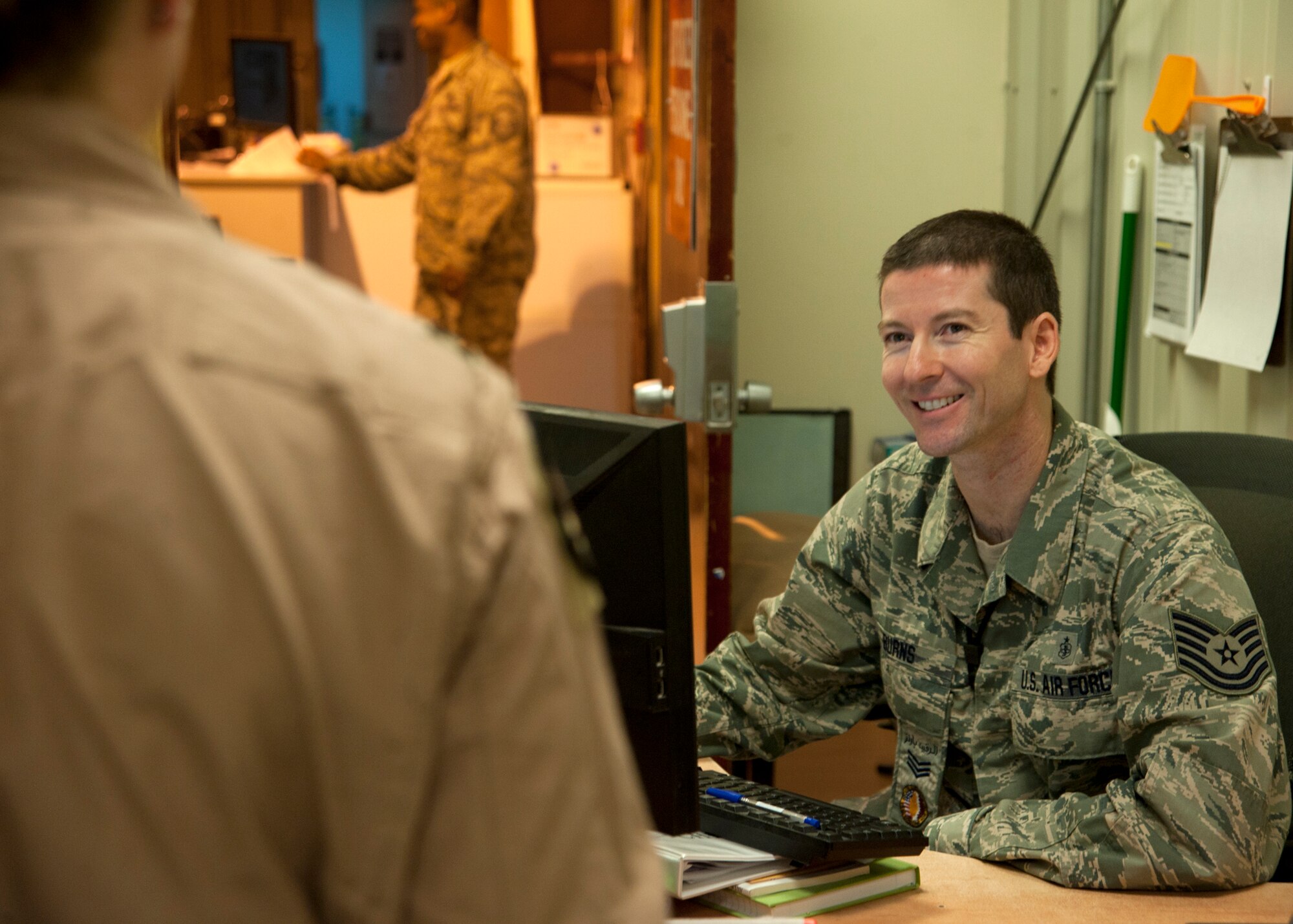 Tech. Sgt. David Burns processes an aircrew member through emigrations at the 379th Air Expeditionary Wing in Southwest Asia, Aug. 8, 2013. Burns is a 379th AEW Host Nation Coordination Cell customs and immigrations liaison deployed from Joint Base San Antonio, Texas. (U.S. Air Force photo/Senior Airman Bahja J. Jones) 