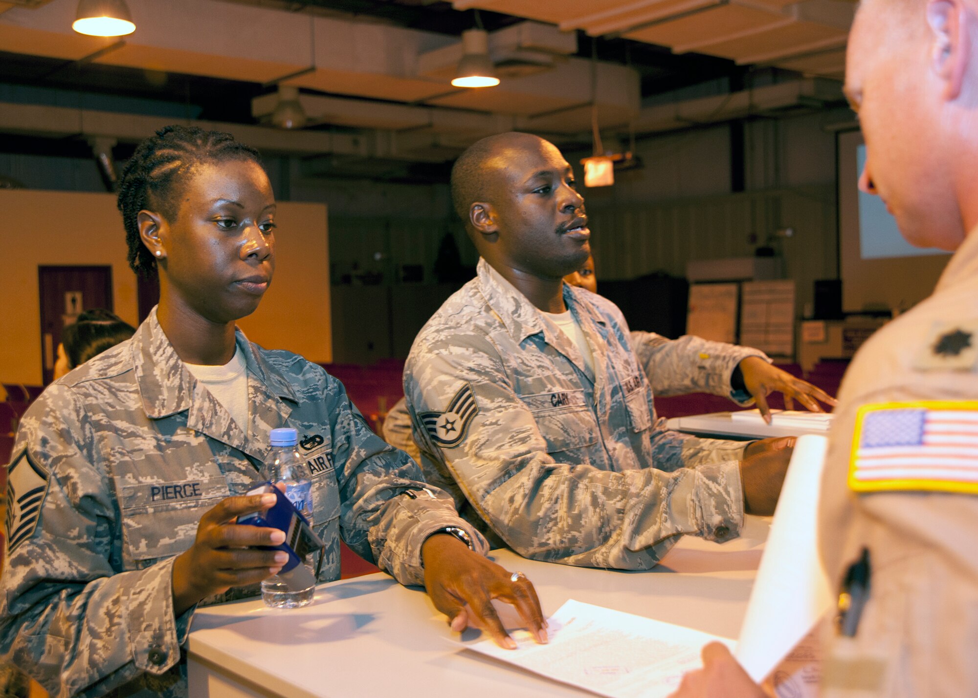 Master Sgt. Shantay L. Pierce and Staff Sgt. Derek Cary in-process incoming service members at the 379th Air Expeditionary Wing in Southwest Asia, Aug. 8, 2013. Pierce is the 379th AEW Host Nation Coordination Cell customs and immigrations superintendent deployed from Altus Air Force base, Okla., and Cary is the 379th Expeditionary Force Support Squadron Personnel Support Contingency Operations team NCO in charge deployed from Pope Army Air Field, Fort Bragg, N.C. (U.S. Air Force photo/Senior Airman Bahja J. Jones) 