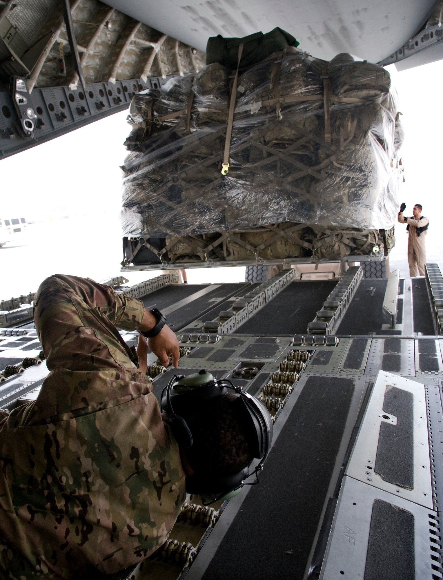 Tech. Sgt. Dequan Barthell, left, and Senior Airman Justin Baez, right, 817th Expeditionary Airlift Squadron Detachment 1, loadmasters guide pallets onto a C-17 Globemaster III prior to departure in Kandahar, Afghanistan July 25, 2013. The loadmasters are responsible for maintaining the aircraft’s center of gravity throughout all stages of flight. (U.S. Air Force photo/Staff Sgt. Krystie Martinez)